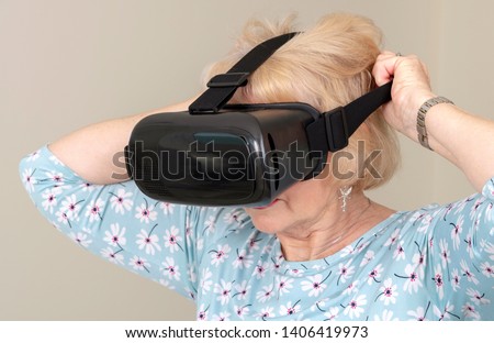 Portsmouth UK, May 2019. Elderly woman pull over her head a pair of virtual reality goggles