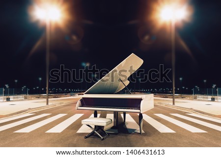 Piano and song concept..White piano in city street at night.Urban music and night entertainment.