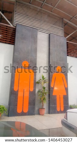 bathroom toilet with big male female orange sign