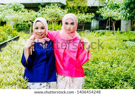 Beautiful female model wearing peplum dress and kebaya with hijab  a modern lifestyle outfit for Muslim woman isolated over white background. Eidul fitri fashion and beauty concept.
