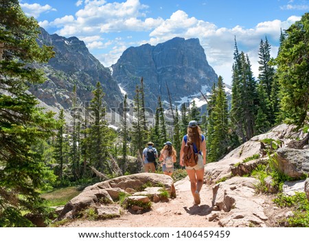 Family on summer vacation hiking trip in the mountains.People hiking on Emerald Lake Trail. Friends exploring Colorado mountains. Estes Park, Rocky Mountains National Park, Colorado, USA. Royalty-Free Stock Photo #1406459459