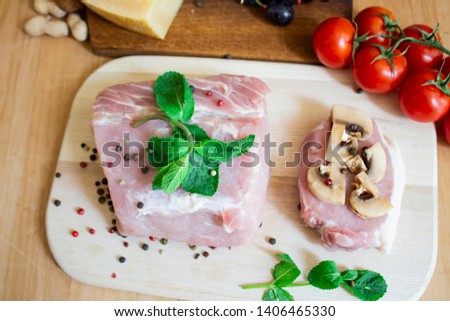 Meat of pork or beef for cooking. Pepper with mint and cherry tomatoes. Chop with mushrooms. On a wooden background. copy space