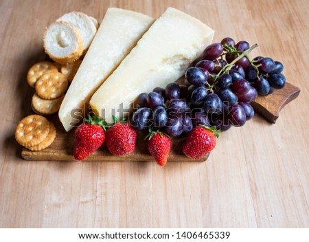 Cheese with grapes and strawberries, cracker, nuts, fruits and nuts. Cheese on a visible background. Copy space