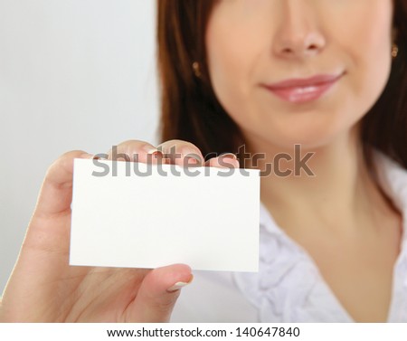 Businesswoman showing and handing a blank business card. Focus on card