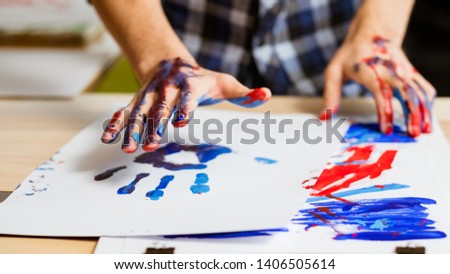 Art therapy class school. Colorful man hand print on white paper. Artist hands smeared with paint. Hobby education.