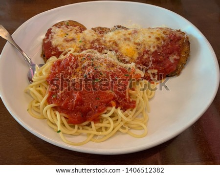 Delicious eggplant parmesan meal with spaghetti noodles and marinara sauce.