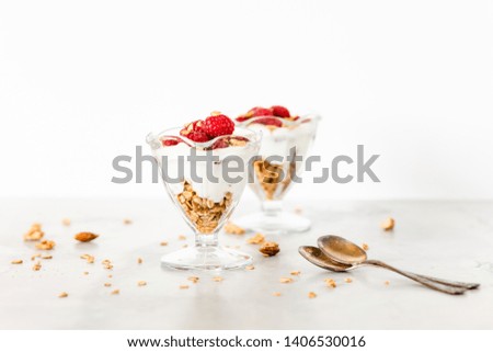 Fresh Raspberries on Top of Granola and Yogurt Parfait On Light Background 