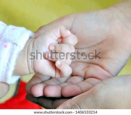 Newborn baby hand. concept of child care, feeling safe, parent love. Concept- Newborn babies and their parents. 
blur background