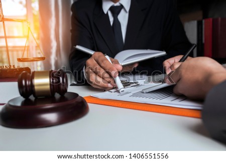 Group of businesspeople meeting or lawyers discussing contract papers and workplace with book and documents while sitting at the table in office,  Concepts of law.
