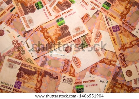 Banknotes of Russian currency face value of 5,000 rubles scattered on the table are a sign of riches and prosperity.