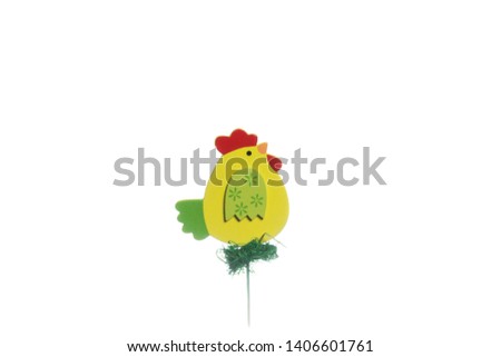 A wooden figure of a small yellow chicken on a white background