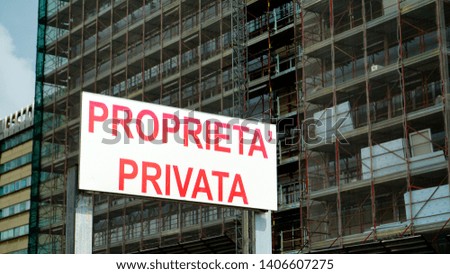 Signboard with the word PRIVATE PROPERTY in Italian as seen from below outside a building site in the city