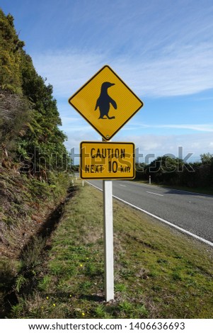 Warning sign in New Zealand: Caution, Pinguins ahead. On a windy road at the west coast of the South Island.