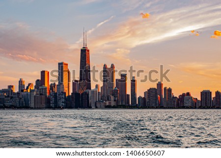 Cityscape of downtown Chicago at colorful sunset with lake foreground