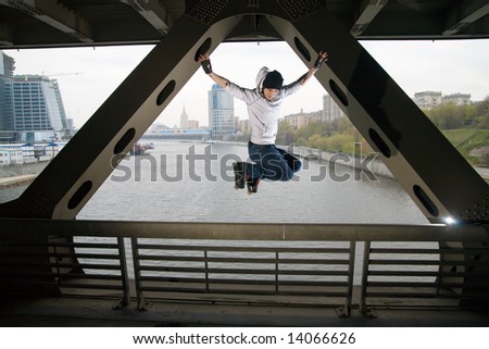 Roller man jumping at bridge over Moscow river.