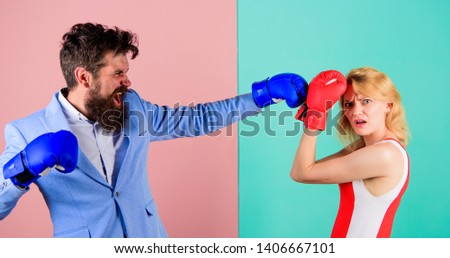 Couple in love competing in boxing. Female and male boxers fighting in gloves. Domination concept. Gender battle. Gender equal rights. Gender equality. Man formal suit and athletic woman boxing fight.