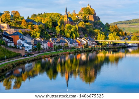 Medieval Saarburg town reflecting in Saar river on a sunny autumn day, Saarland, Germany Royalty-Free Stock Photo #1406675525