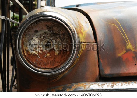 Background picture with an old rusty retro car with a broken headlight