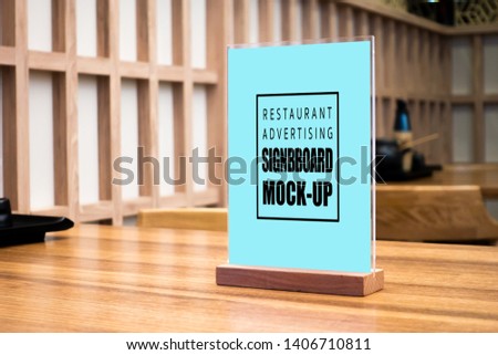 Mock up perspective blank vertical advertising signboard in acrylic frame with clipping path on table in Japanese style restaurant ,empty space for insert menu list or promotion 
