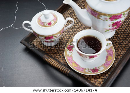 Coffee and a set of antique cup on the black marble table