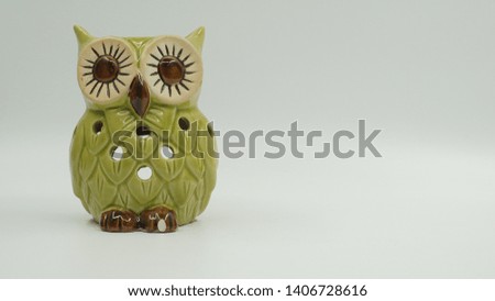 Cute ceramic owl on bright background.                               