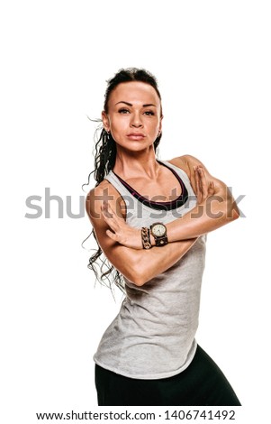 Portrait of strong female bodybuilder with crossed muscular hands