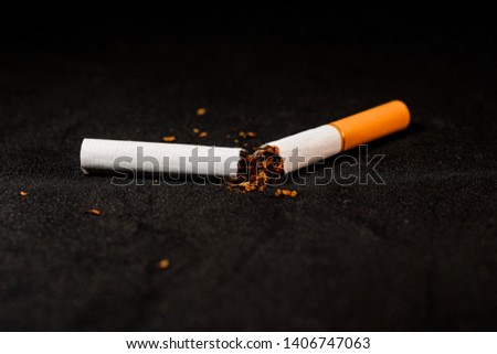stop smoking concept, a broken cigarette isolated against black, World Tobacco Day