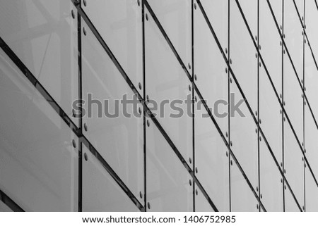 Black and white shot of a facade made of bolted glass tiles on a modern high-rise building