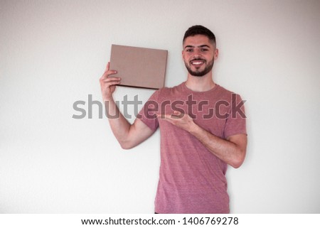 smiling guy with a package in his hands. Handsome guy works in the delivery service.