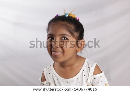 Beautiful girl in white dress with a flower on a white background,Beautiful happy little girl with long dark hair and dress looking at camera. studio shoot