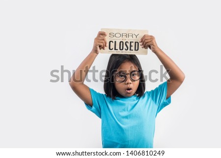 Little girl hand holding wood sign "closed"