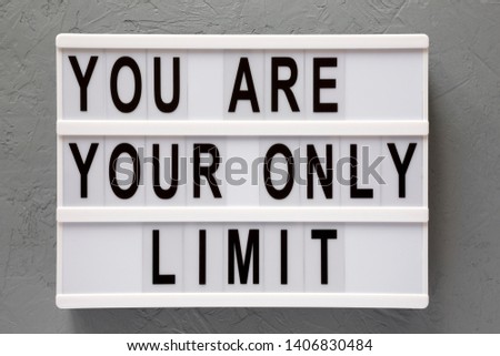 'You are your only limit' words on a modern board over gray surface, top view. Overhead, from above. Flat lay. Close-up.
