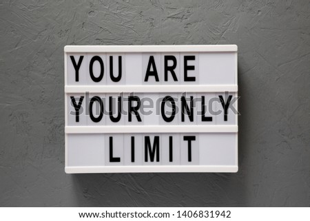 'You are your only limit' words on a modern board over concrete surface, top view. Overhead, from above. Flat lay. 
