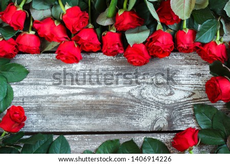 Bouquet of red roses on a wooden background with space for text, top view, holiday concept, selective focus