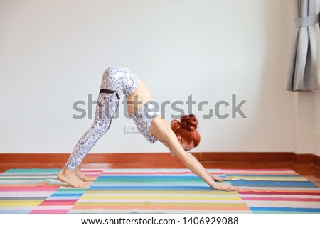 Side view of young attractive caucasian woman in black and white sportswear practicing or exercise yoga indoor. balance between body and mental. (healthy life concept)