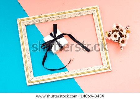 flowers vase and white gift box, heart pillow, flat lay on blue and pink paper background with copy space. Soft effect filter. Minimal concept