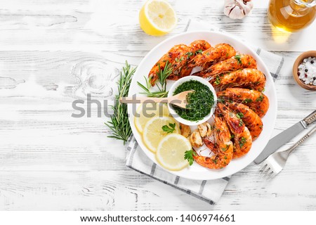 Grilled tiger shrimp with parsley sauce and lemon.