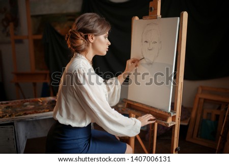 Female painter in studio, pencil sketch on easel