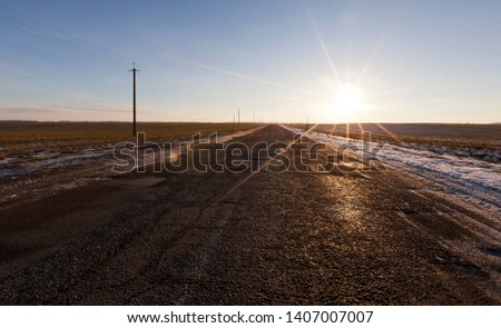 picture of a road in winter during sunset sunset. Rays of the sun in the frame