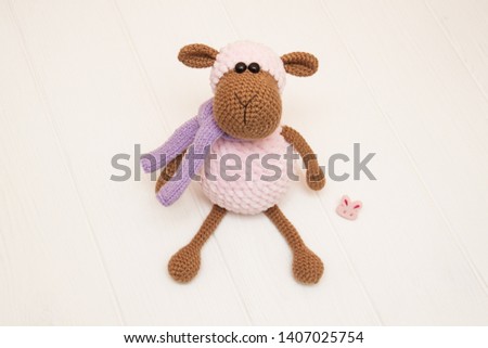 little crocheted pink sheep in a scarf