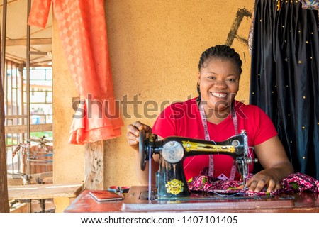 young black tailor smiling while she's working Royalty-Free Stock Photo #1407101405