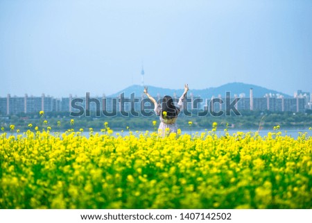 A beautiful woman is taking pictures in a flower garden In Seoul, South Korea