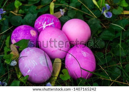 a group of vibrant painted easter eggs in the grass