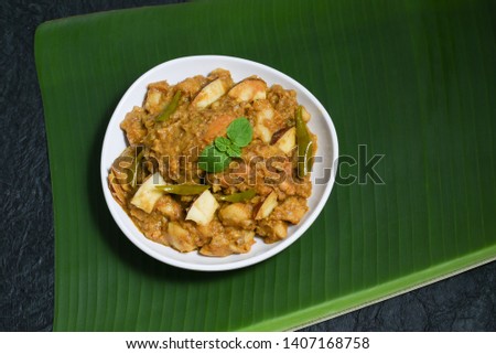 Malabar style Kozhi Pidi or Kunji Pathal is soft rice dumplings cooked in roasted coconut chicken curry. Popular South Indian meal, snack or side dish served on banana leaf in Kerala India.