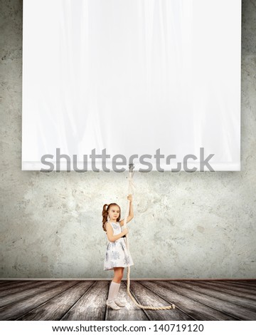 Little pretty girl pulling blank banner. Place for text