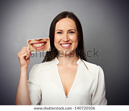 smiley healthy woman holding picture with dirty yellow teeth