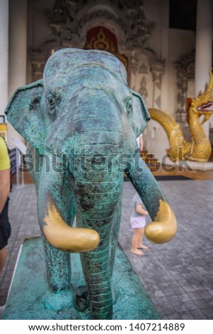 The bronze elephant statue in front of ancient asian temple