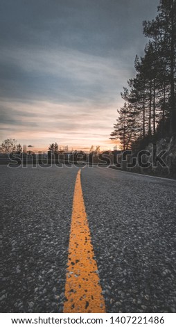 Portrait Picture, road in mountains, Norway. Beautiful sunset or sunrise in Viking land. Yellow road markings, family trip in summer, beautiful Norway. Mountains rivers and lakes