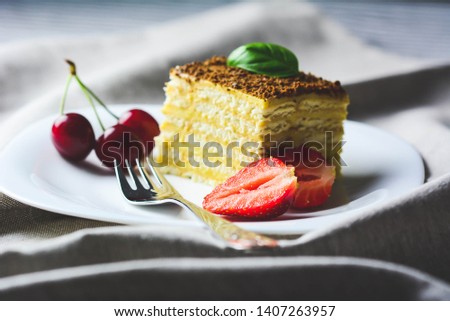 Various cake pieces of chocolate and vanilla filling.Basil, cherries and strawberries. Horizontal, selective focus-toned picture.
