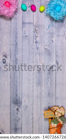 Easter eggs and bunny overhead on wooden background with copy space vertical